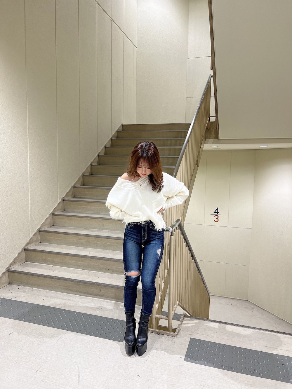 ブルー系のデニムパンツ、ホワイト系のニット/セーター、ブラック系のブーツを着用したレディースの冬コーディネートの4枚目の写真