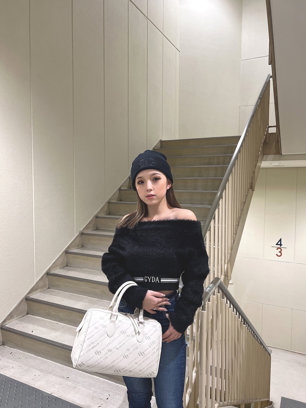 ブラック系のニット/セーター、ブルー系のデニムパンツ、ブラック系のブーツを着用したレディースの秋コーディネートの3枚目の写真