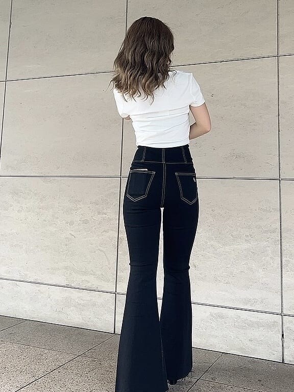 ブラック系のデニムパンツ、ホワイト系のTシャツ/カットソー、ブラック系のサンダルを着用したレディースの夏コーディネートの3枚目の写真