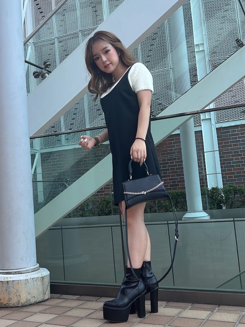 ホワイト系のニット/セーター、ブラック系のハンドバッグ、ブラック系のブーツを着用したレディースの夏コーディネートの7枚目の写真