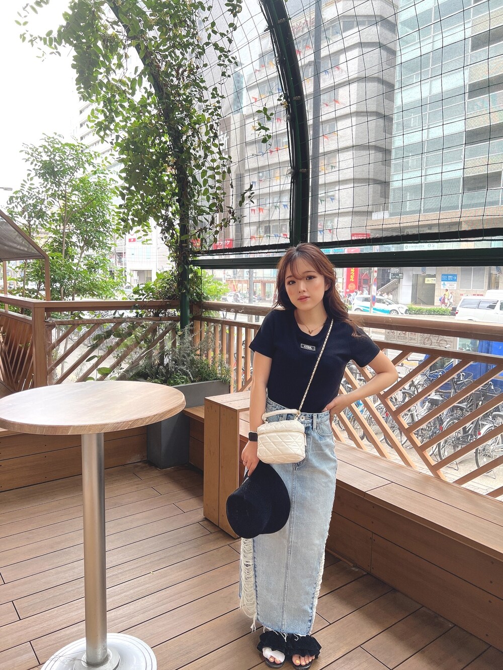 ブラック系のTシャツ/カットソー、ブルー系のデニムスカート、ベージュ系のハットを着用したレディースの春コーディネートの2枚目の写真