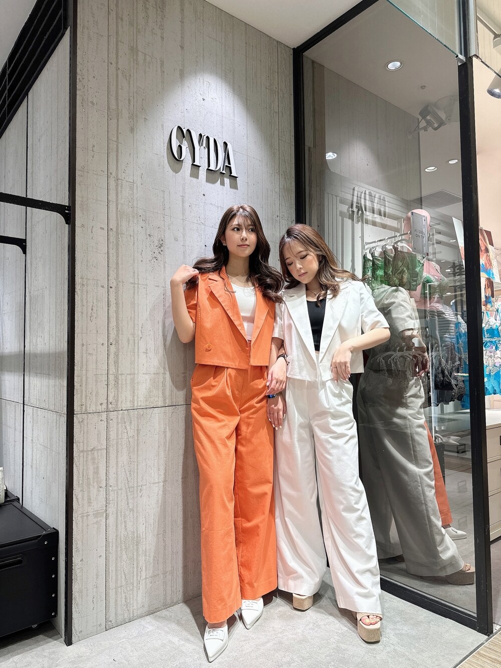 ホワイト系のテーラードジャケット、ホワイト系のスラックス、ホワイト系のサンダルを着用したレディースの春コーディネートの3枚目の写真