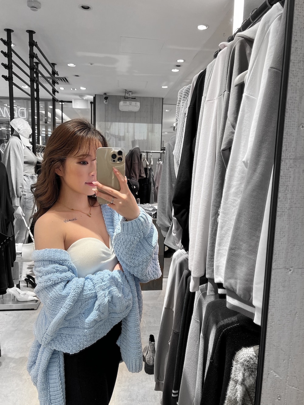 ブルー系のカーディガン/ボレロ、ホワイト系のチューブトップ、ブラック系のデニムパンツを着用したレディースの春コーディネートの2枚目の写真