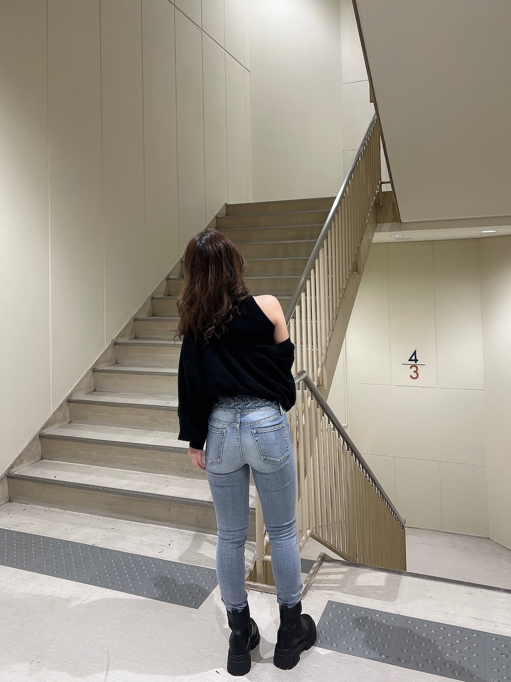 ブラック系のカーディガン/ボレロ、ブルー系のデニムパンツ、ブラック系のブーツを着用したレディースの冬コーディネートの4枚目の写真