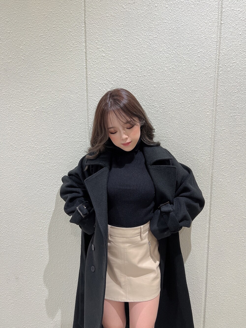 ブラック系のニット/セーター、ブラック系のトレンチコート、ブラック系のブーツを着用したレディースの冬コーディネートの5枚目の写真