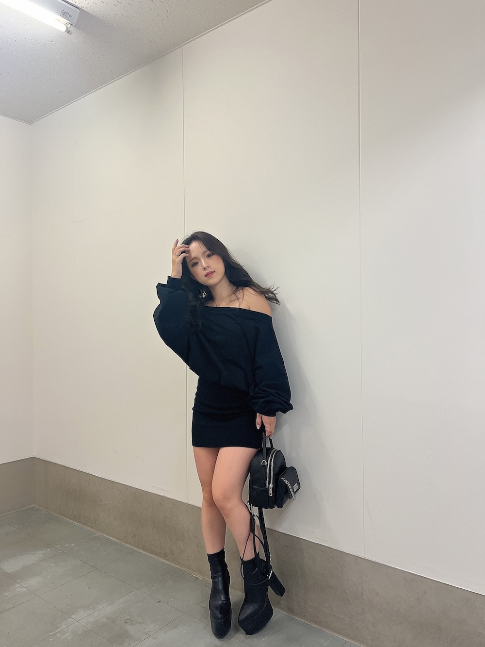 ブラック系のワンピース、ブラック系のブーツ、ブラック系のバックパック/リュックを着用したレディースの秋コーディネートの2枚目の写真