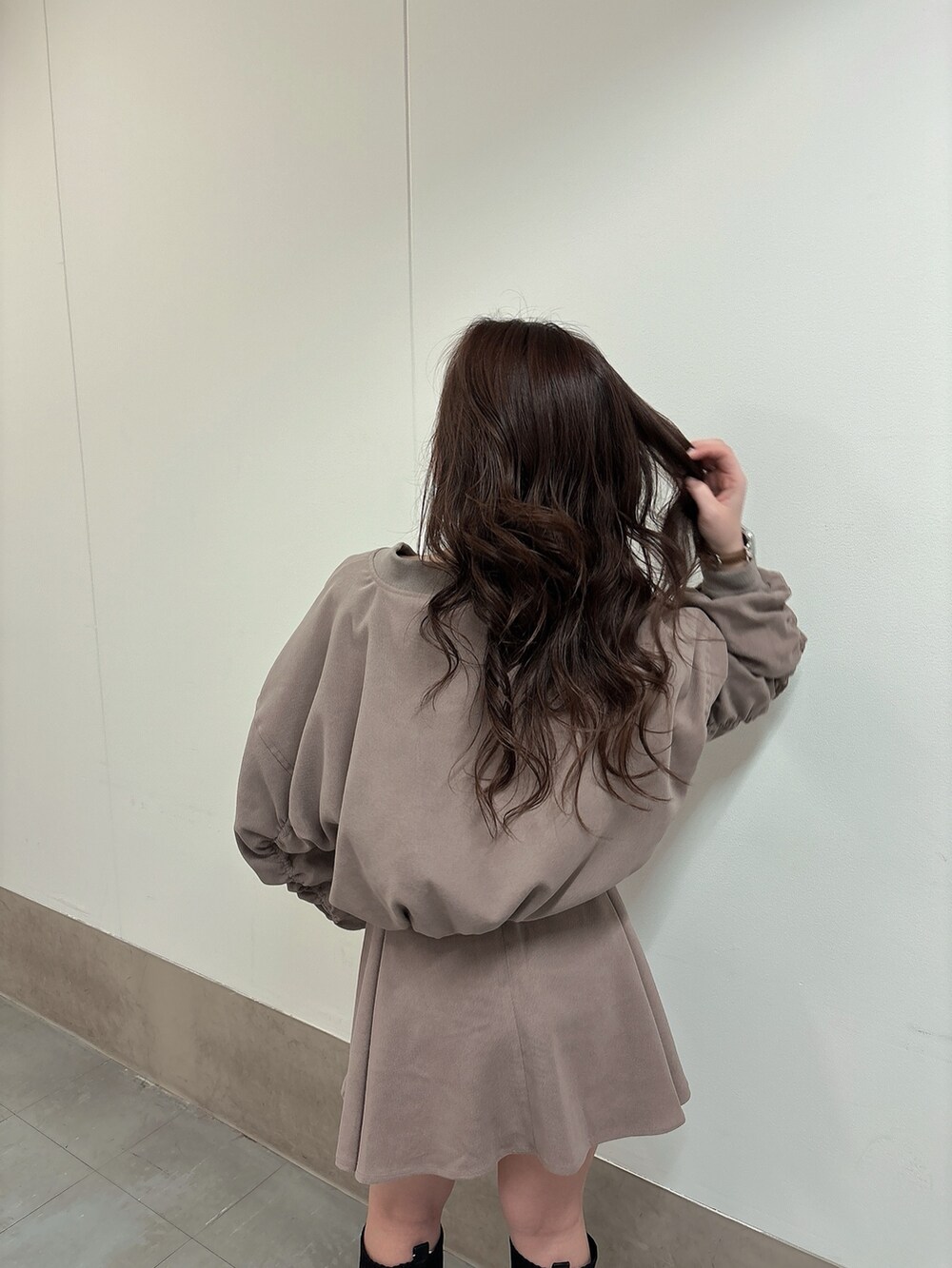 ブラック系のブーツ、ベージュ系のブルゾン、ベージュ系のスカートを着用したレディースの冬コーディネートの4枚目の写真