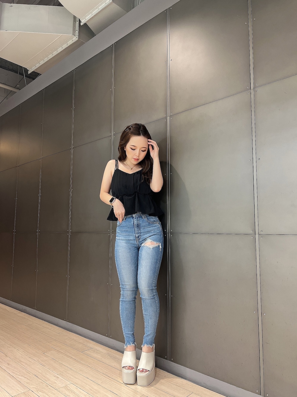 ブラック系のキャミソール、ブルー系のデニムパンツ、ホワイト系のサンダルを着用したレディースの夏コーディネートの3枚目の写真