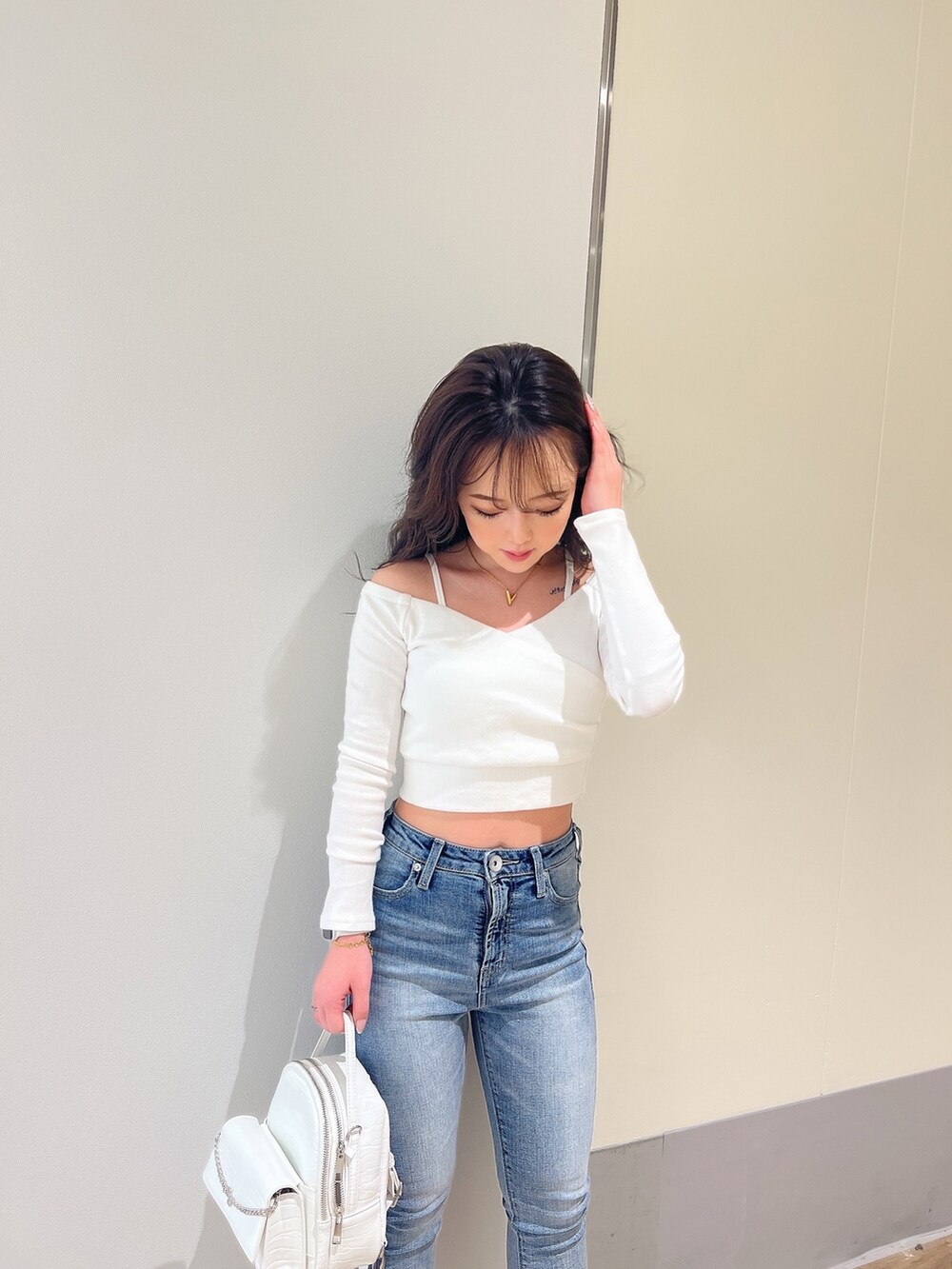 ホワイト系のTシャツ/カットソー、ブルー系のデニムパンツ、ホワイト系のパンプスを着用したレディースの春コーディネートの4枚目の写真