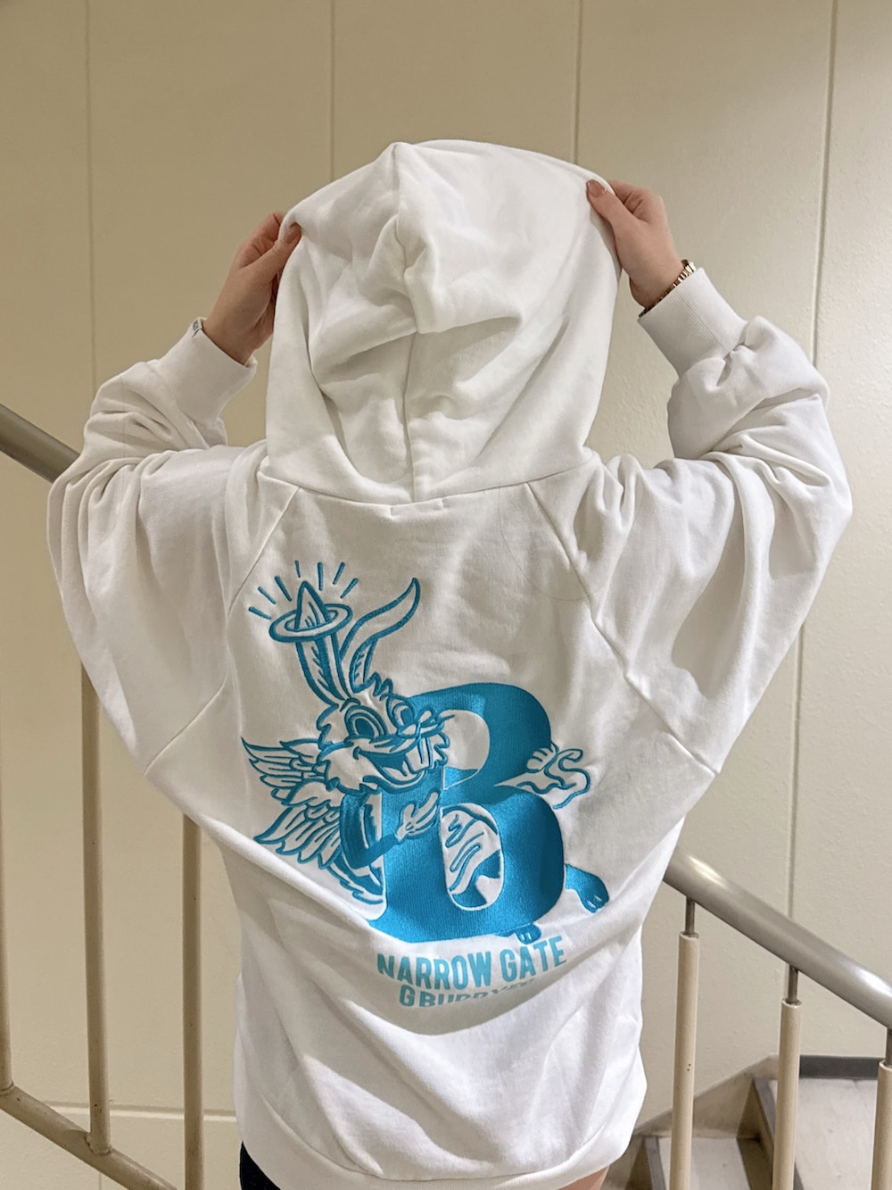 ホワイト系のパーカー、ブラック系のブーツを着用したレディースの冬コーディネートの5枚目の写真