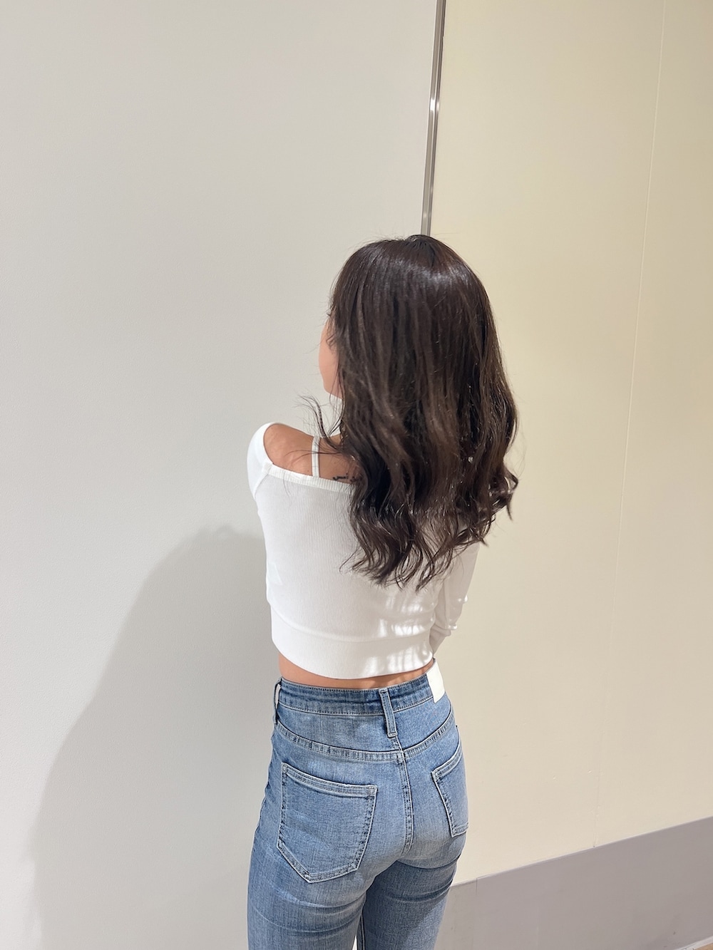 ホワイト系のTシャツ/カットソー、ブルー系のデニムパンツ、ホワイト系のパンプスを着用したレディースの春コーディネートの6枚目の写真