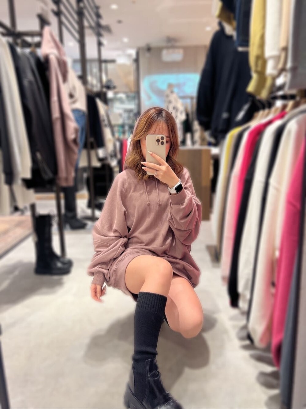 ブラック系のブーツ、ピンク系のパーカーを着用したレディースの秋コーディネートの2枚目の写真