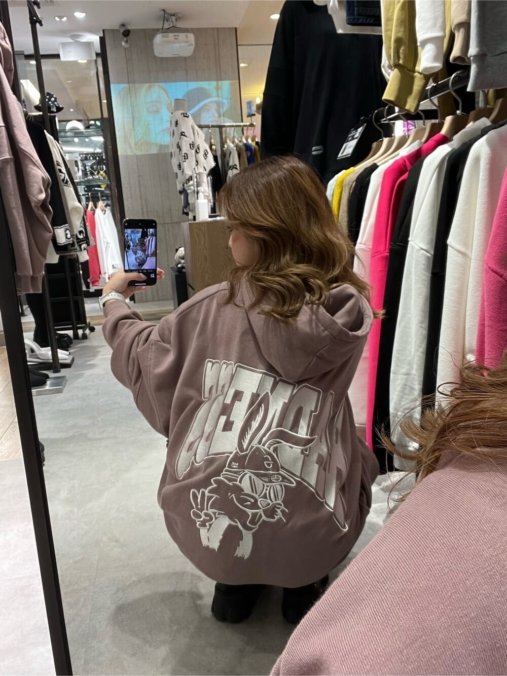 ブラック系のブーツ、ピンク系のパーカーを着用したレディースの秋コーディネートの5枚目の写真