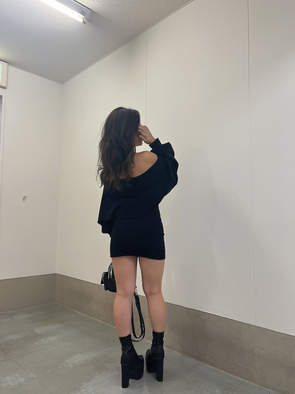 ブラック系のワンピース、ブラック系のブーツ、ブラック系のバックパック/リュックを着用したレディースの秋コーディネートの4枚目の写真