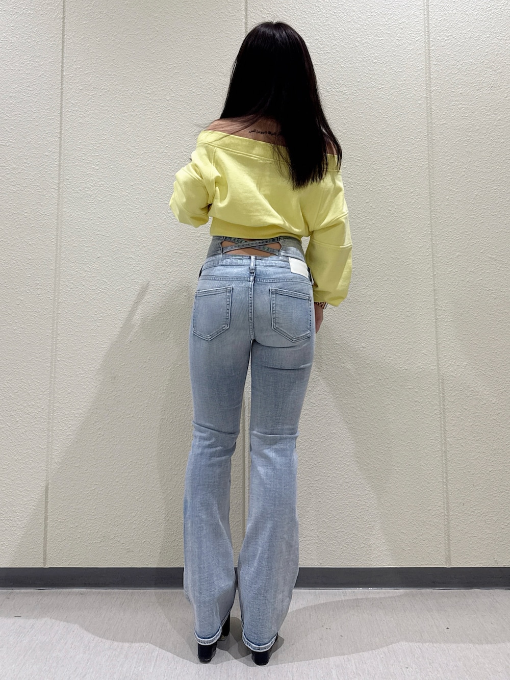 ブルー系のデニムパンツ、イエロー系のスウェット、ブラック系のブーツを着用したレディースの冬コーディネートの3枚目の写真