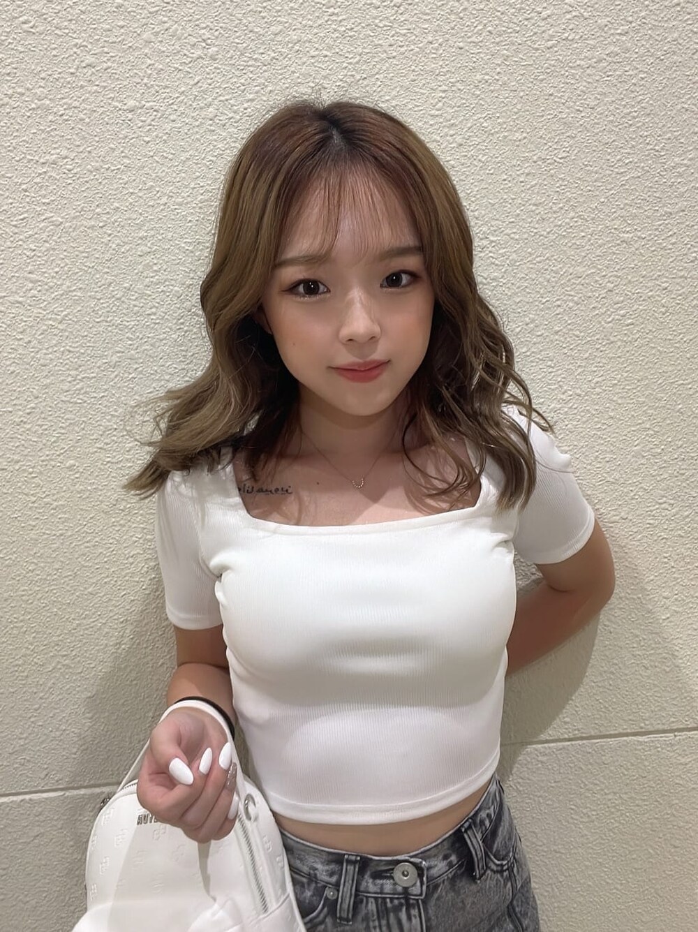 ホワイト系のバックパック/リュック、ブラック系のデニムスカート、ホワイト系のパンプスを着用したレディースの夏コーディネートの4枚目の写真