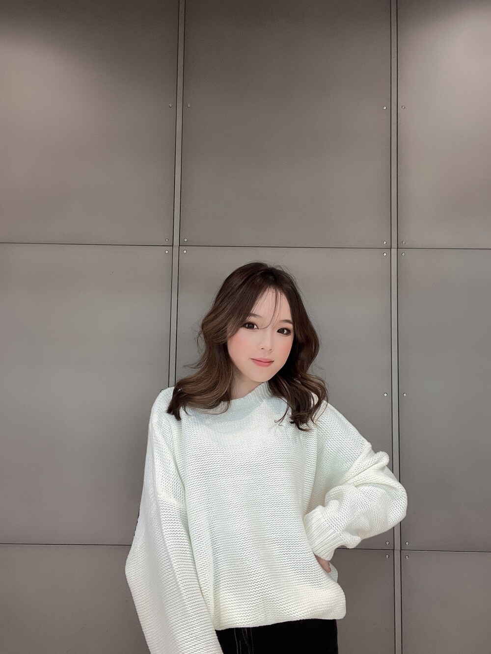 ホワイト系のニット/セーター、ブラック系のデニムパンツ、ホワイト系のパンプスを着用したレディースの冬コーディネートの6枚目の写真