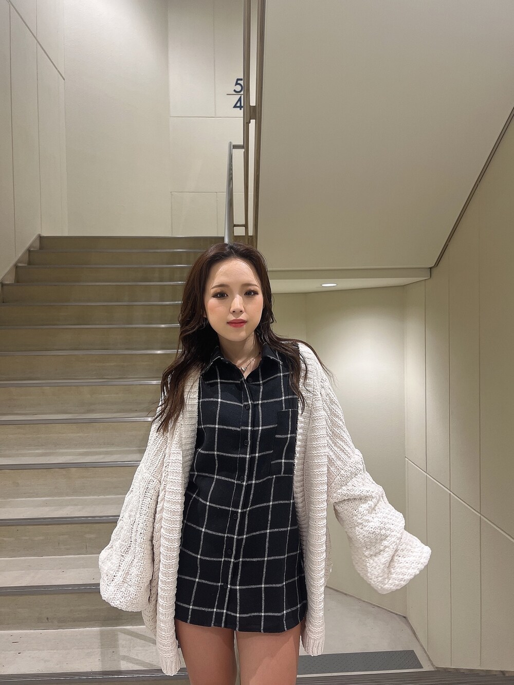 ブルー系のシャツ/ブラウス、ホワイト系のカーディガン/ボレロ、ブラック系のブーツを着用したレディースの秋コーディネートの3枚目の写真