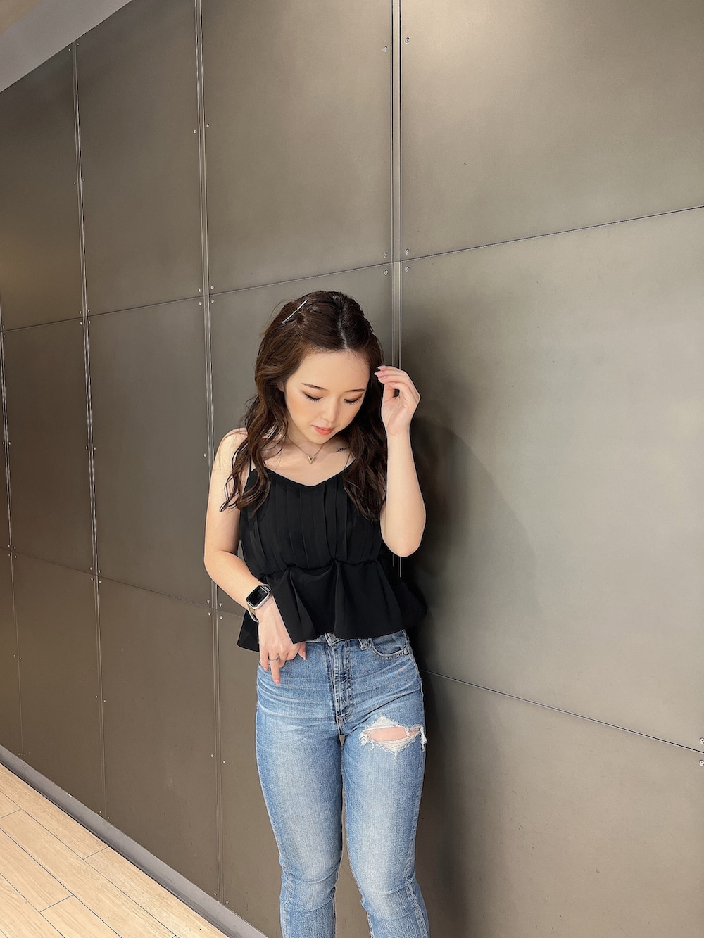 ブラック系のキャミソール、ブルー系のデニムパンツ、ホワイト系のサンダルを着用したレディースの夏コーディネートの4枚目の写真