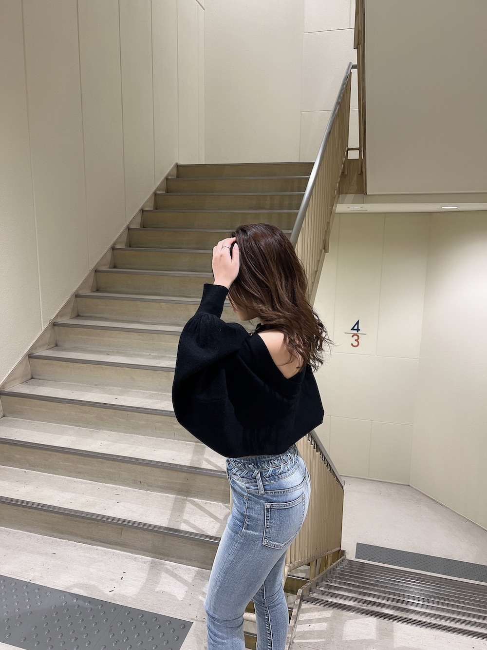 ブラック系のカーディガン/ボレロ、ブルー系のデニムパンツ、ブラック系のブーツを着用したレディースの冬コーディネートの7枚目の写真