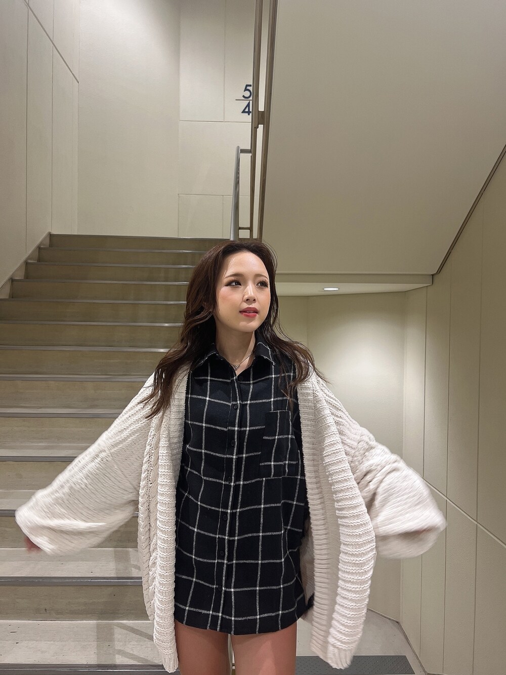 ブルー系のシャツ/ブラウス、ホワイト系のカーディガン/ボレロ、ブラック系のブーツを着用したレディースの秋コーディネートの4枚目の写真