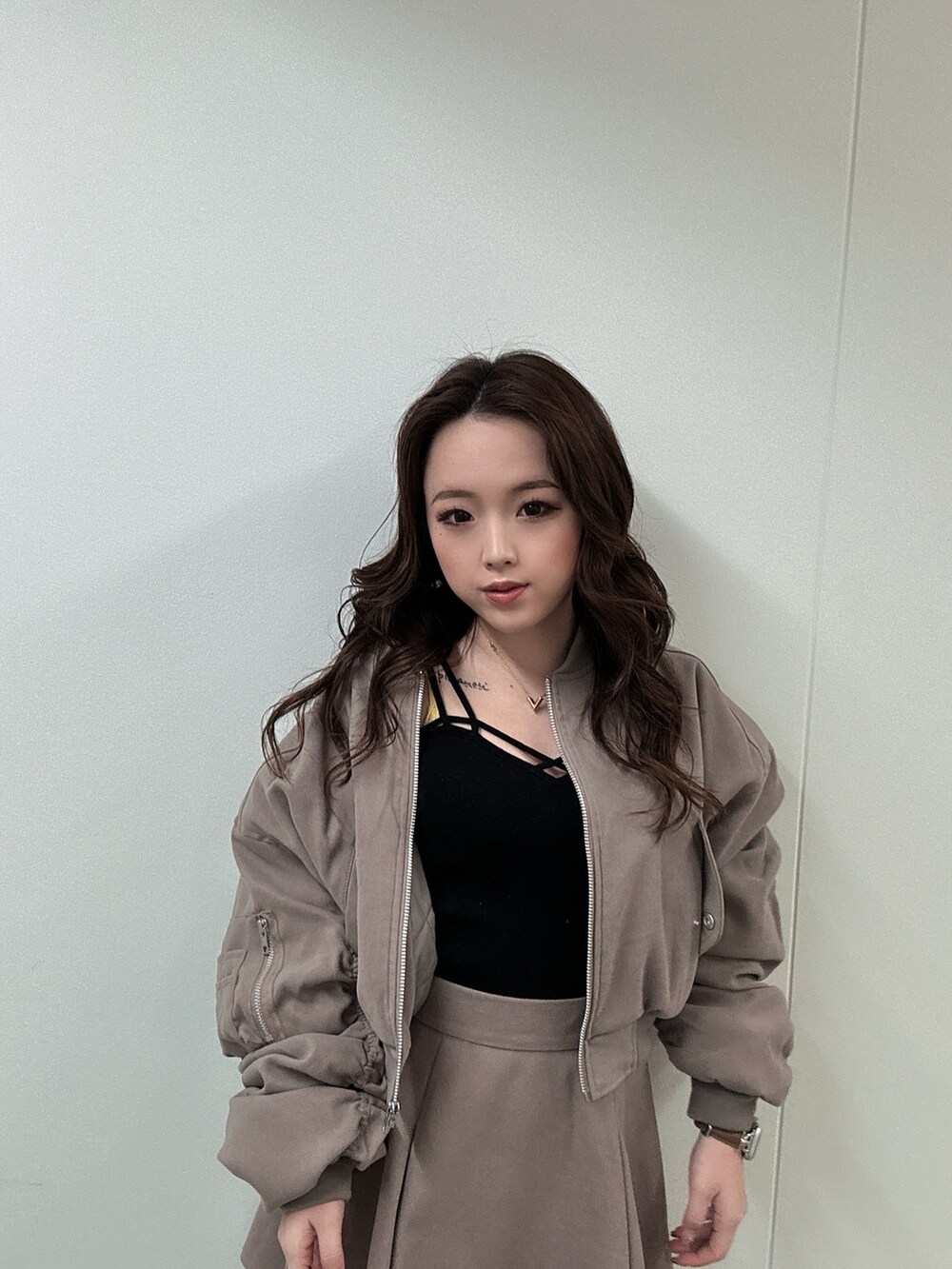 ブラック系のブーツ、ベージュ系のブルゾン、ベージュ系のスカートを着用したレディースの冬コーディネートの3枚目の写真