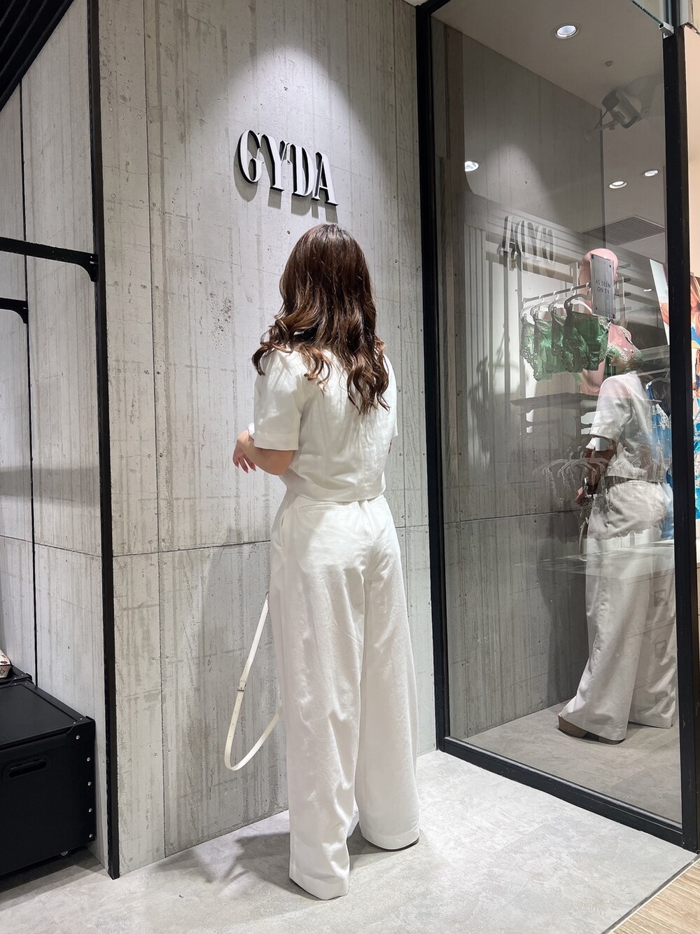 ホワイト系のテーラードジャケット、ホワイト系のスラックス、ホワイト系のサンダルを着用したレディースの春コーディネートの5枚目の写真