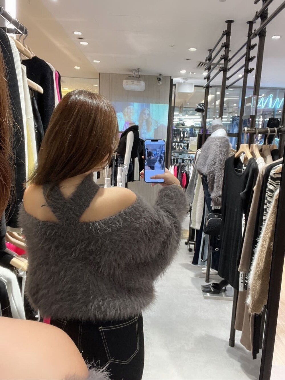 ブラック系のデニムパンツ、グレー系のニット/セーター、ブラック系のブーツを着用したレディースの秋コーディネートの4枚目の写真