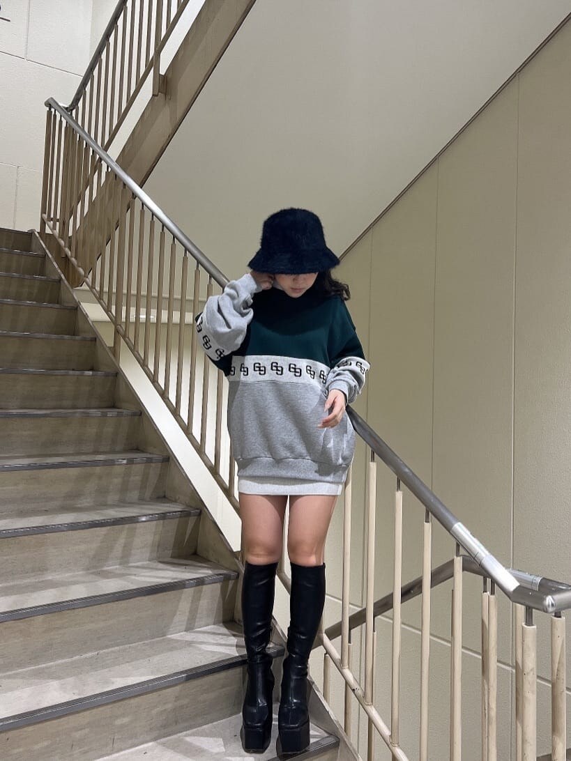 ブラック系のブーツ、ホワイト系のワンピース、グリーン系のスウェットを着用したレディースの秋コーディネートの3枚目の写真