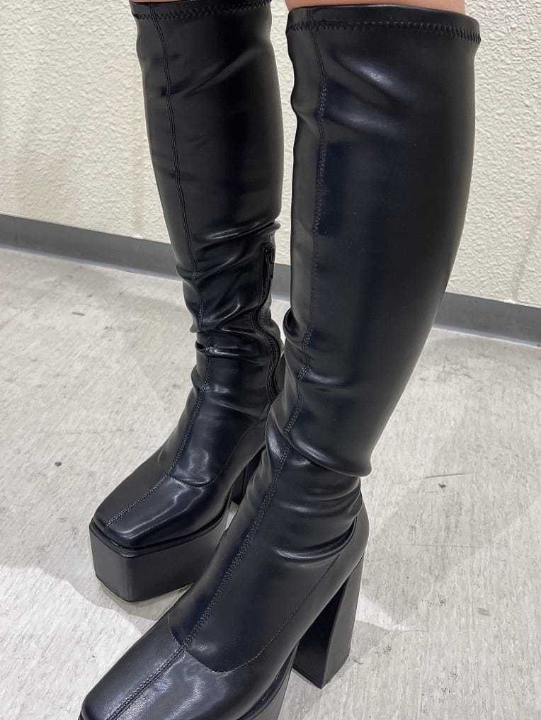 ブラック系のブーツ、ブラック系のその他アウター、ホワイト系のワンピースを着用したレディースの秋コーディネートの8枚目の写真