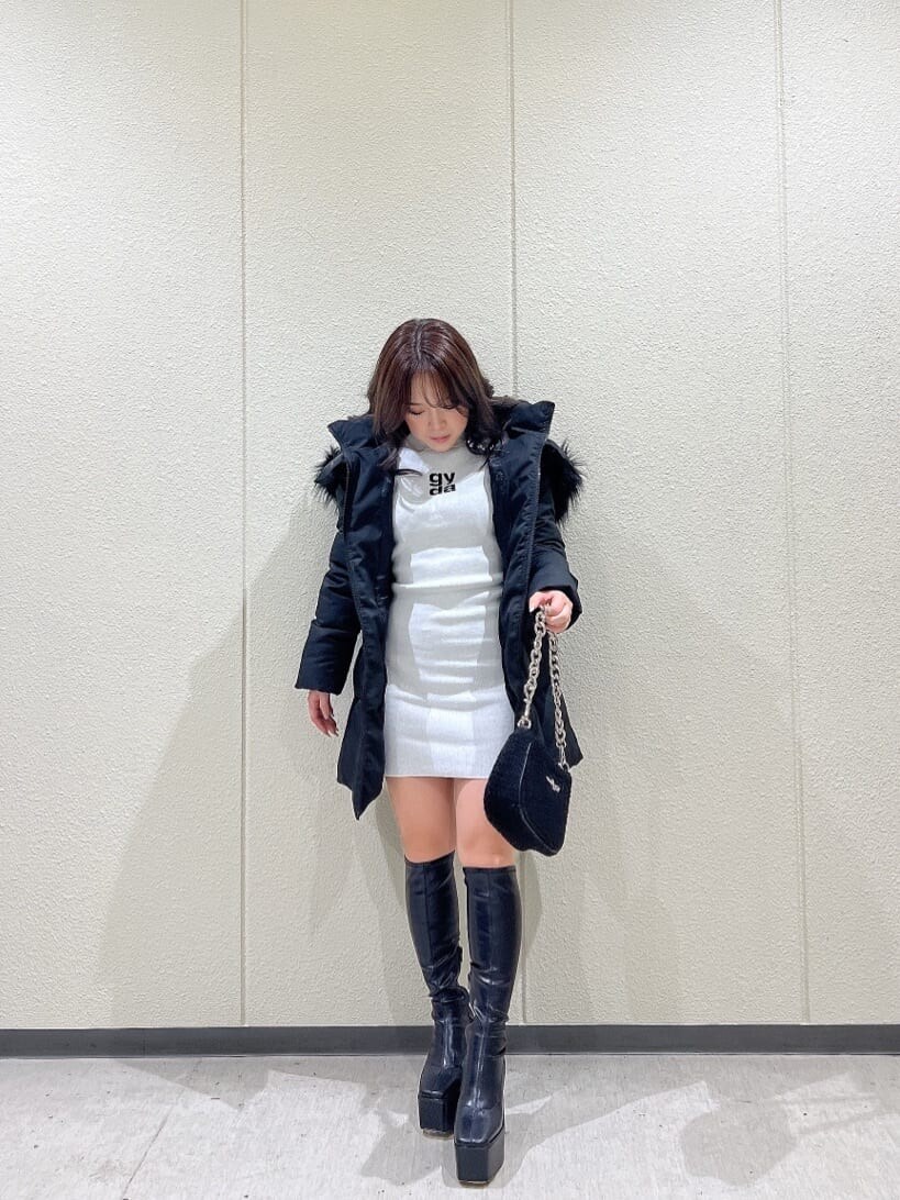 ブラック系のブーツ、ブラック系のその他アウター、ホワイト系のワンピースを着用したレディースの秋コーディネートの4枚目の写真