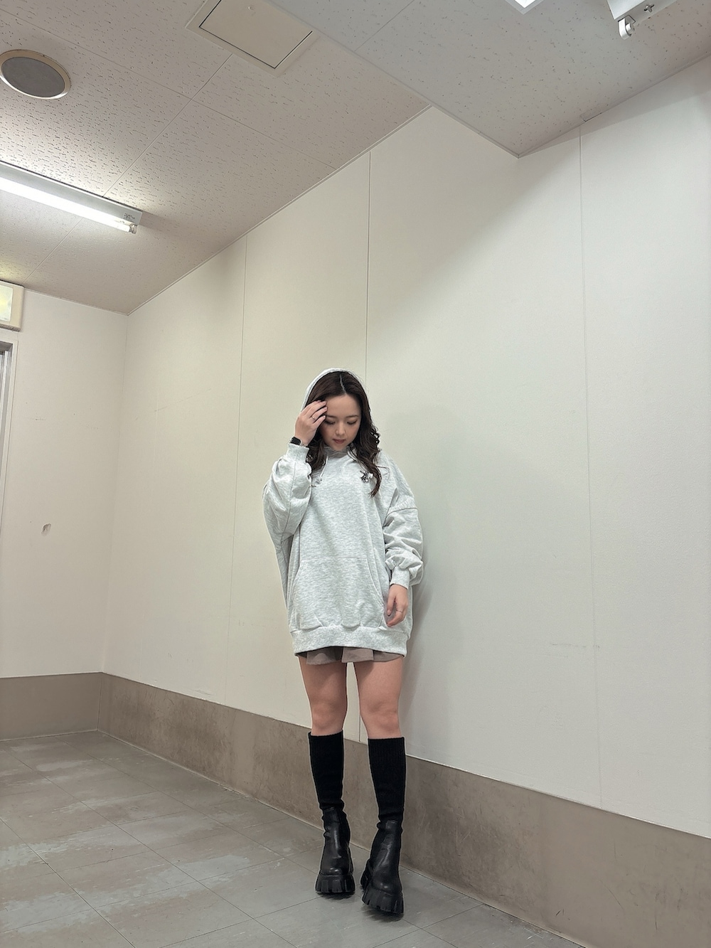 グレー系のパーカー、ブラック系のブーツを着用したレディースの冬コーディネートの4枚目の写真