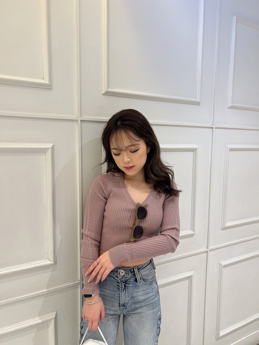 ピンク系のニット/セーター、ブルー系のデニムパンツ、ホワイト系のバックパック/リュックを着用したレディースの冬コーディネートの7枚目の写真