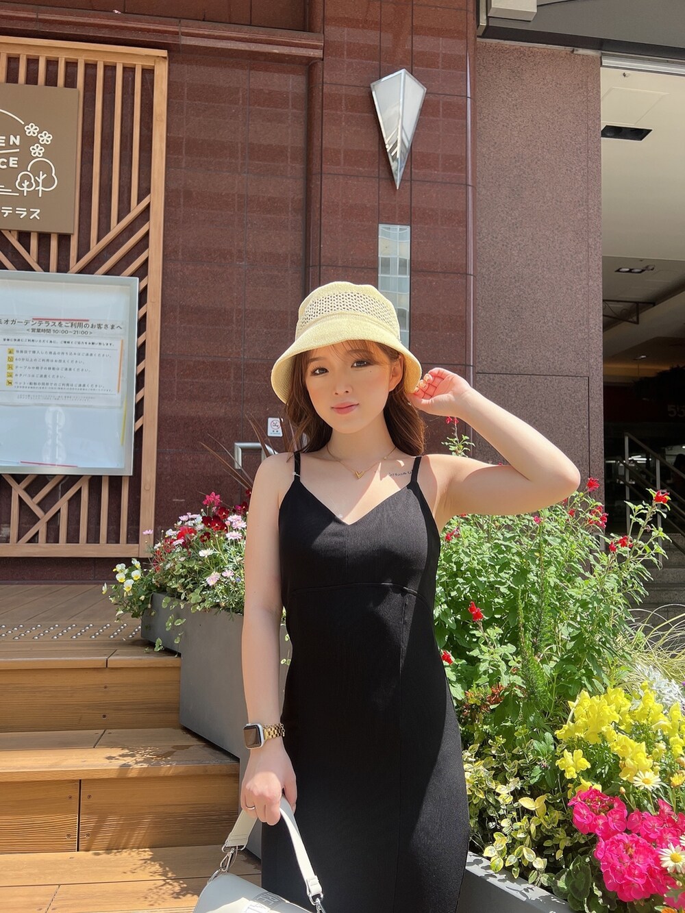 ブラック系のワンピース、ホワイト系のサンダル、ホワイト系のハンドバッグを着用したレディースの春コーディネートの5枚目の写真