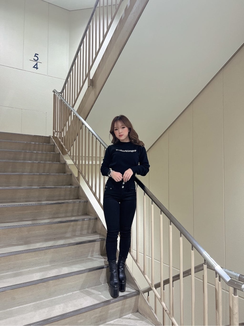 ブラック系のデニムパンツ、ブラック系のブーツ、ブラック系のニット/セーターを着用したレディースの秋コーディネートの2枚目の写真