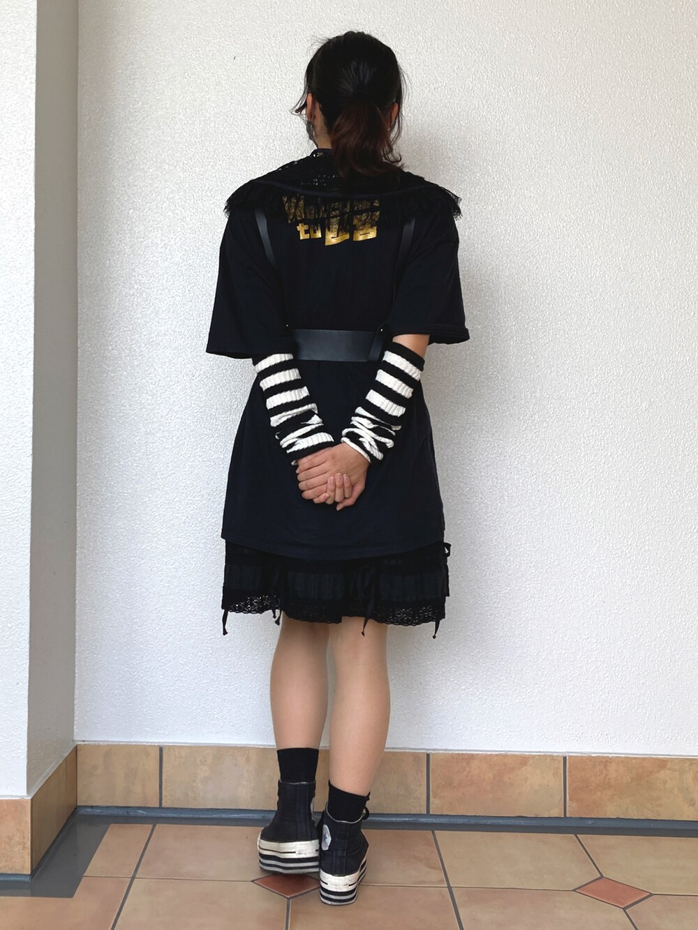 ブラック系のスニーカー、ブラック系のTシャツ/カットソー、ブラック系のスカートを着用したレディースの秋コーディネートの2枚目の写真