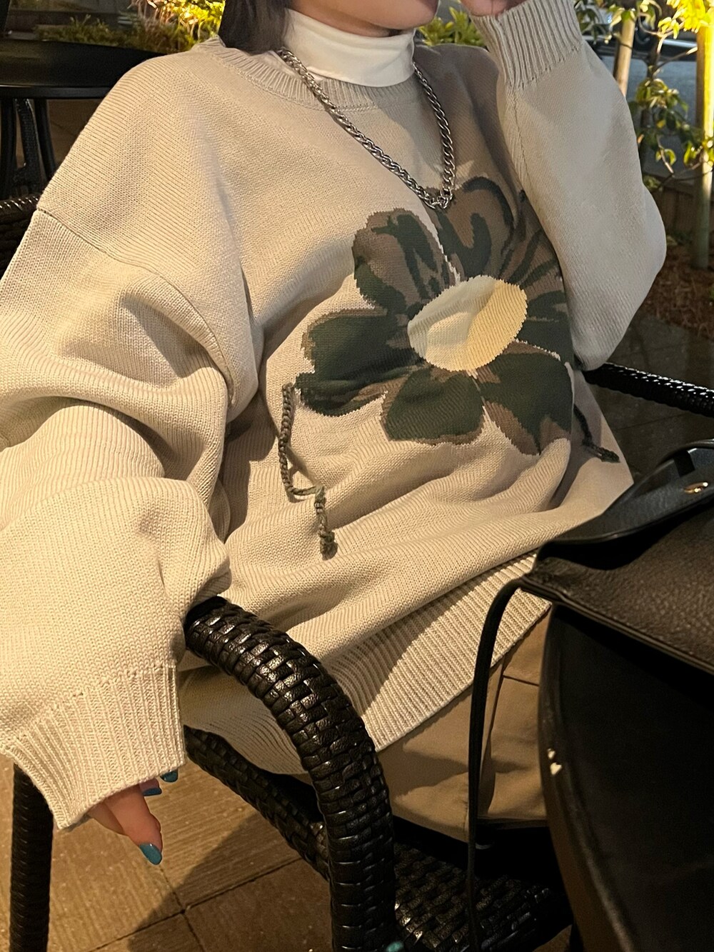 ベージュ系のカーゴパンツ、ホワイト系のスニーカー、ブラック系のショルダーバッグを着用したレディースの秋コーディネートの2枚目の写真