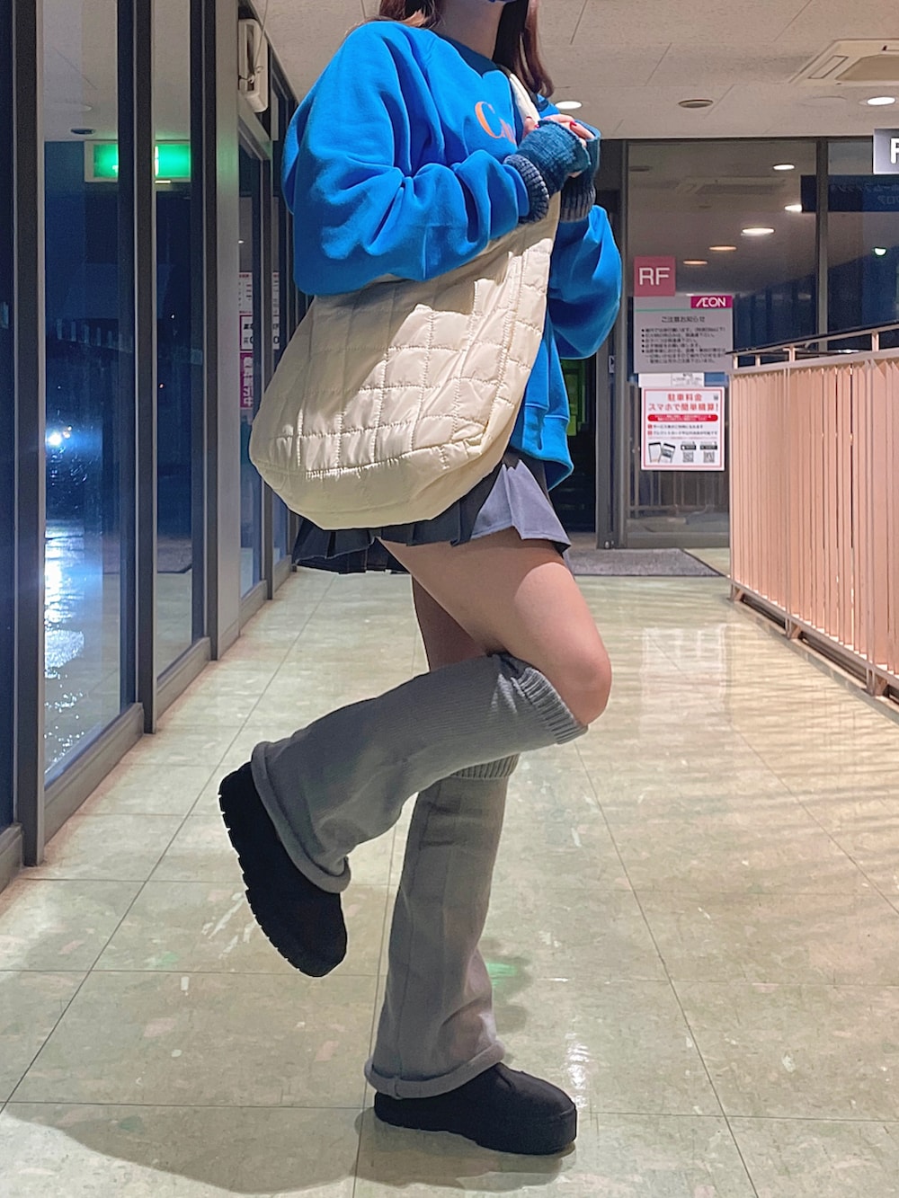 ホワイト系のショルダーバッグ、グレー系のスカート、ブラック系のスニーカーを着用したレディースの秋コーディネートの4枚目の写真