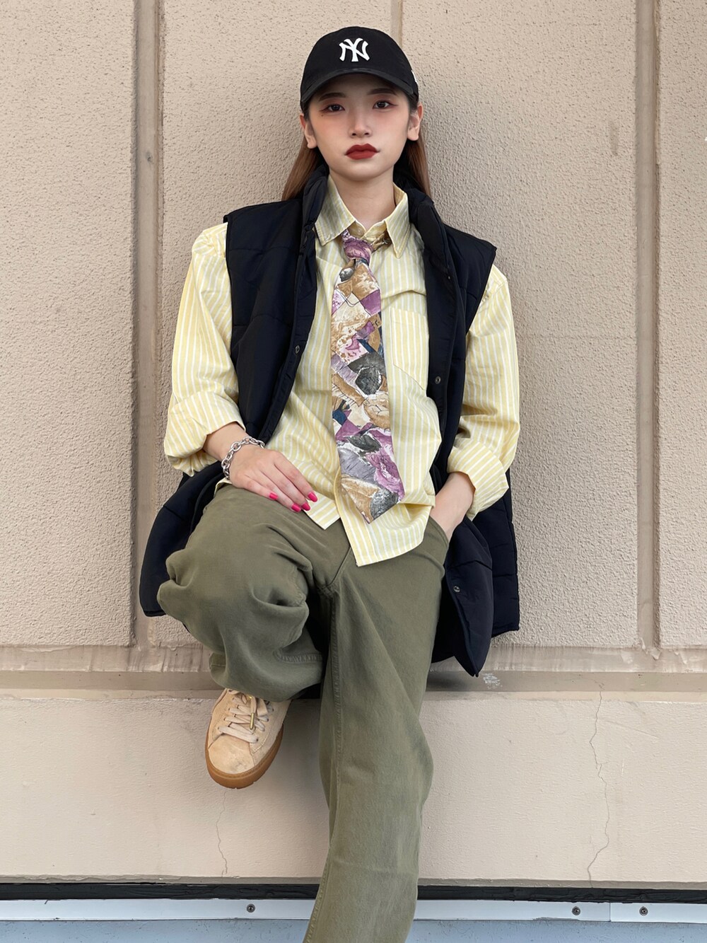 グリーン系のデニムパンツ、ベージュ系のスニーカー、その他のネクタイを着用したレディースの秋コーディネートの3枚目の写真