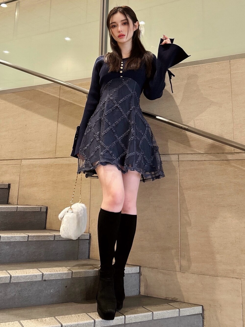 ブルー系のワンピース、ホワイト系のハンドバッグを着用したレディースの秋コーディネートの2枚目の写真