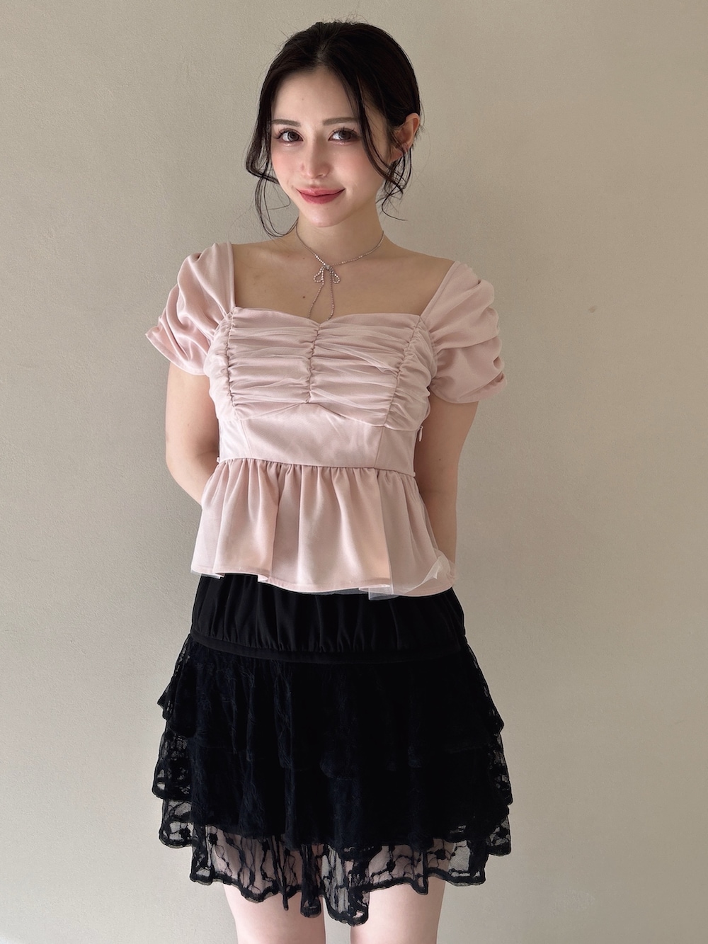 ピンク系のシャツ/ブラウス、ブラック系のスカート、シルバー系のネックレスを着用したレディースの春コーディネートの2枚目の写真