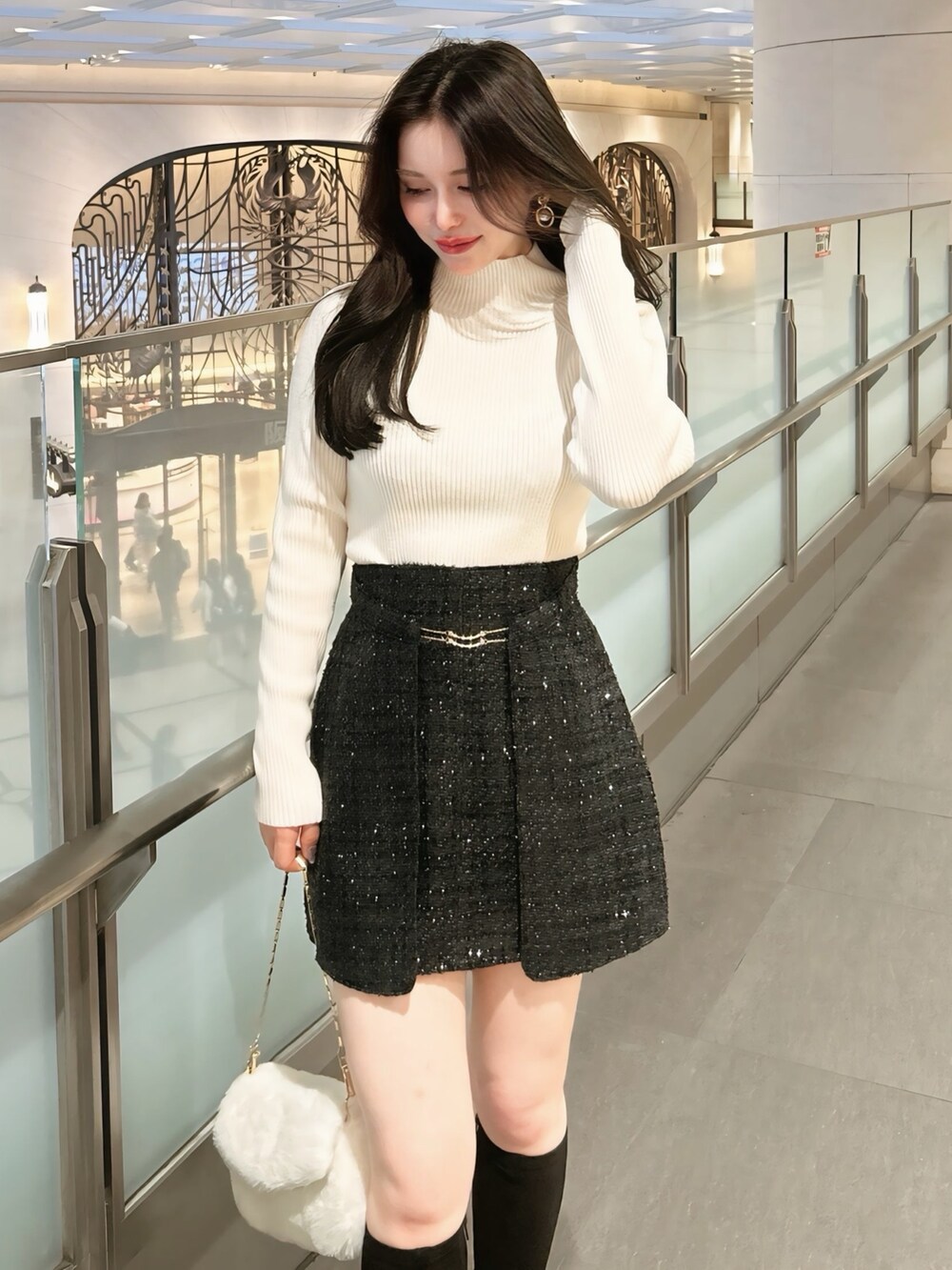 ブラック系のその他アウター、ブラック系のスカート、ホワイト系のニット/セーターを着用したレディースの秋コーディネートの4枚目の写真