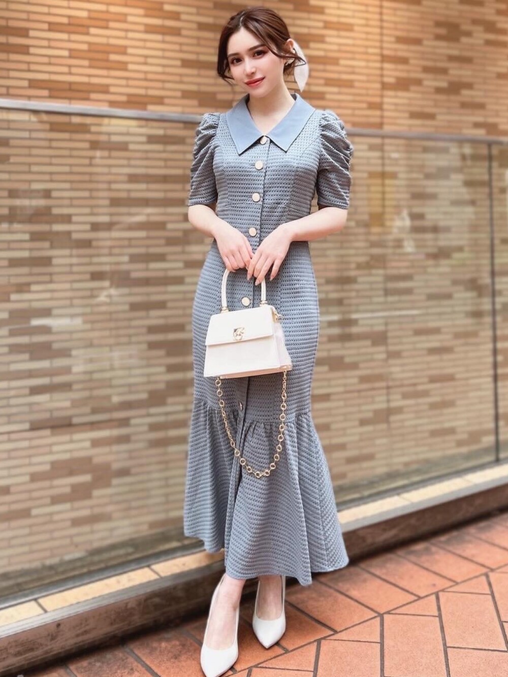 ブルー系のワンピース、ホワイト系のハンドバッグ、ホワイト系のパンプスを着用したレディースの春コーディネートの2枚目の写真