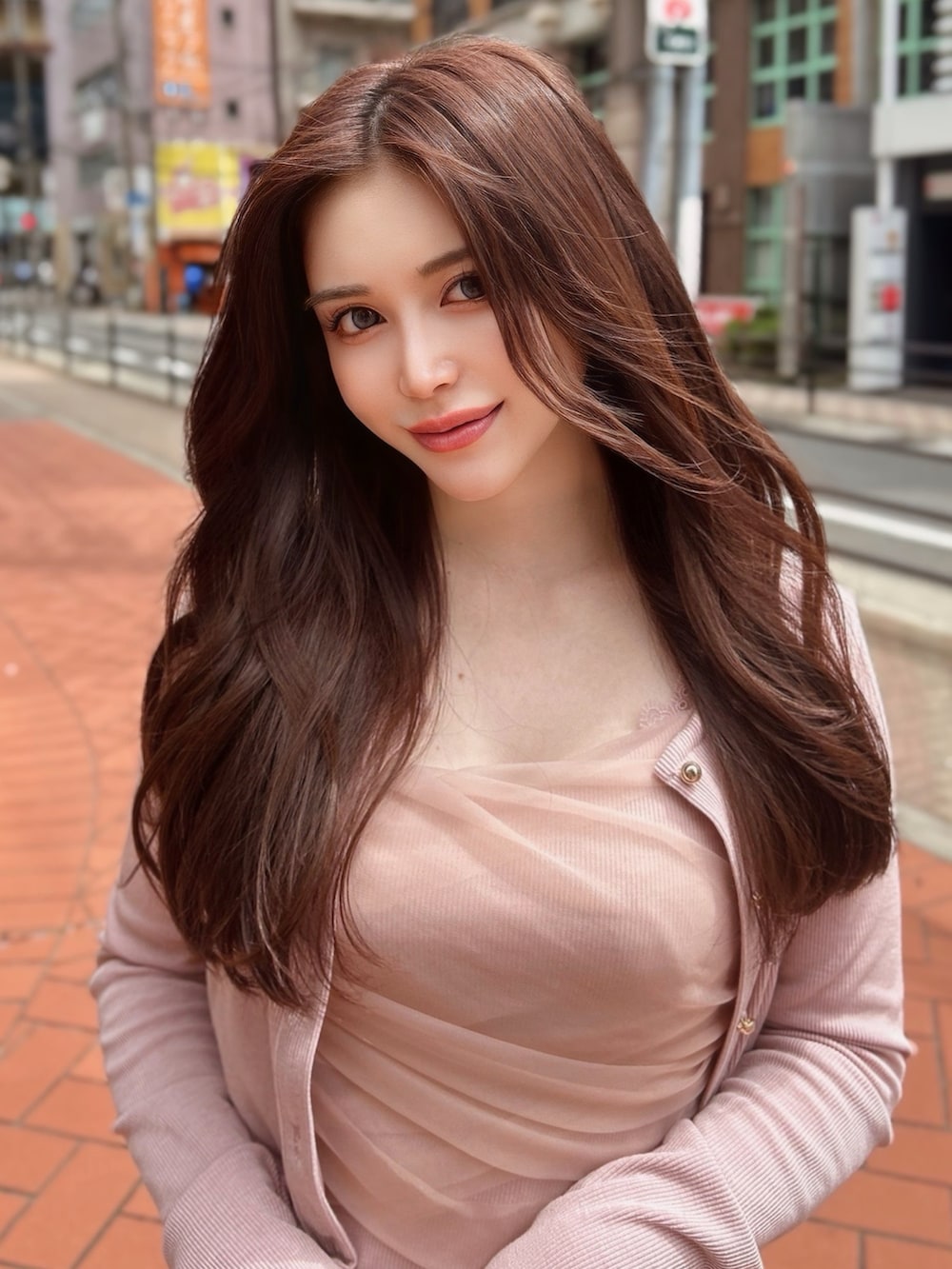 ピンク系のニット/セーター、ブルー系のデニムパンツを着用したレディースの春コーディネートの2枚目の写真