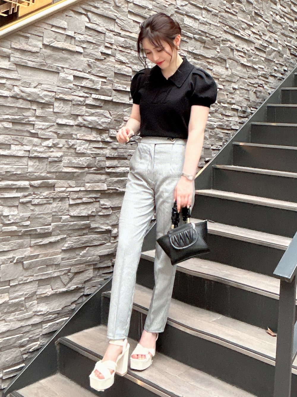 その他のその他パンツ、ブラック系のニット/セーター、ブラック系のハンドバッグを着用したレディースの夏コーディネートの2枚目の写真