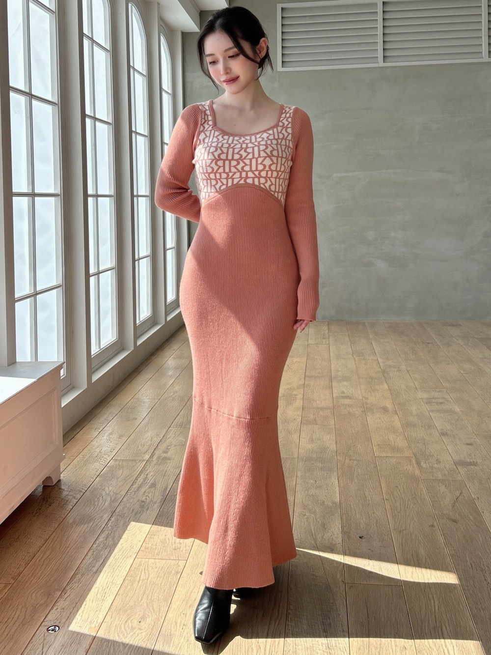 オレンジ系のワンピースを着用したレディースの秋コーディネートの2枚目の写真