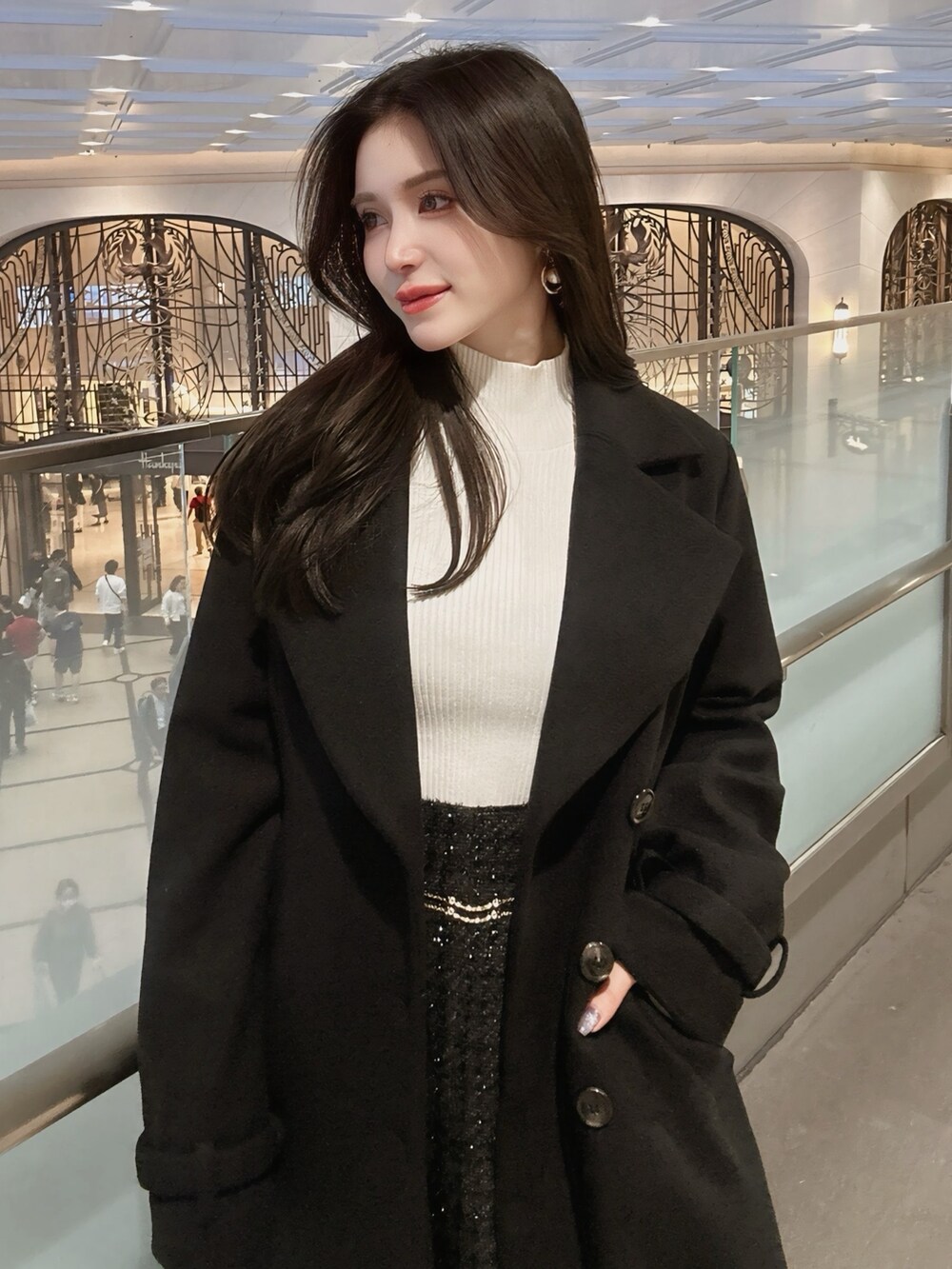 ブラック系のその他アウター、ブラック系のスカート、ホワイト系のニット/セーターを着用したレディースの秋コーディネートの2枚目の写真