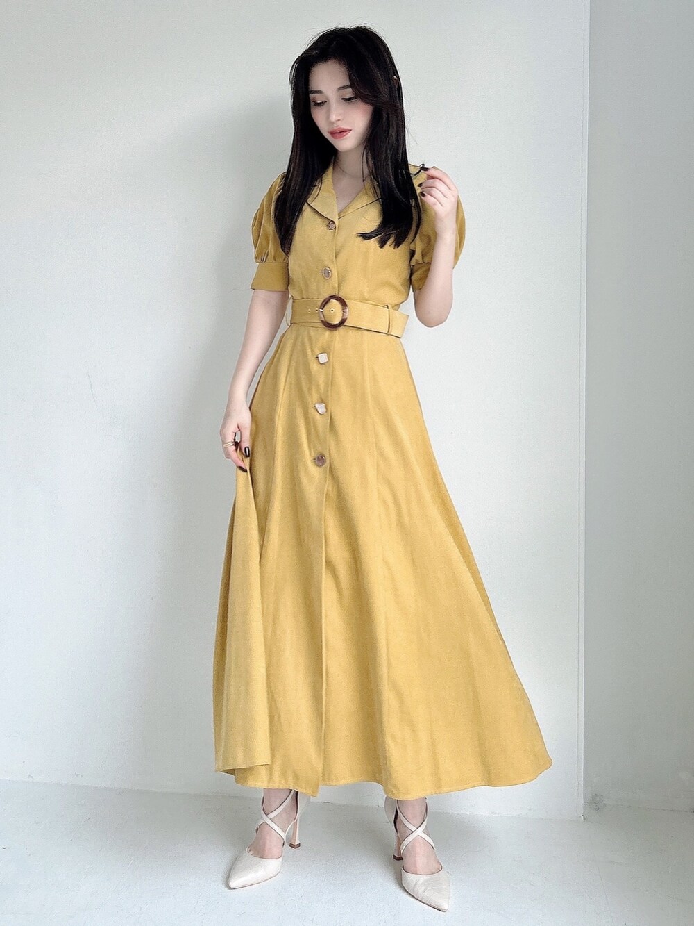 イエロー系のワンピース、ホワイト系のパンプスを着用したレディースの春コーディネートの2枚目の写真