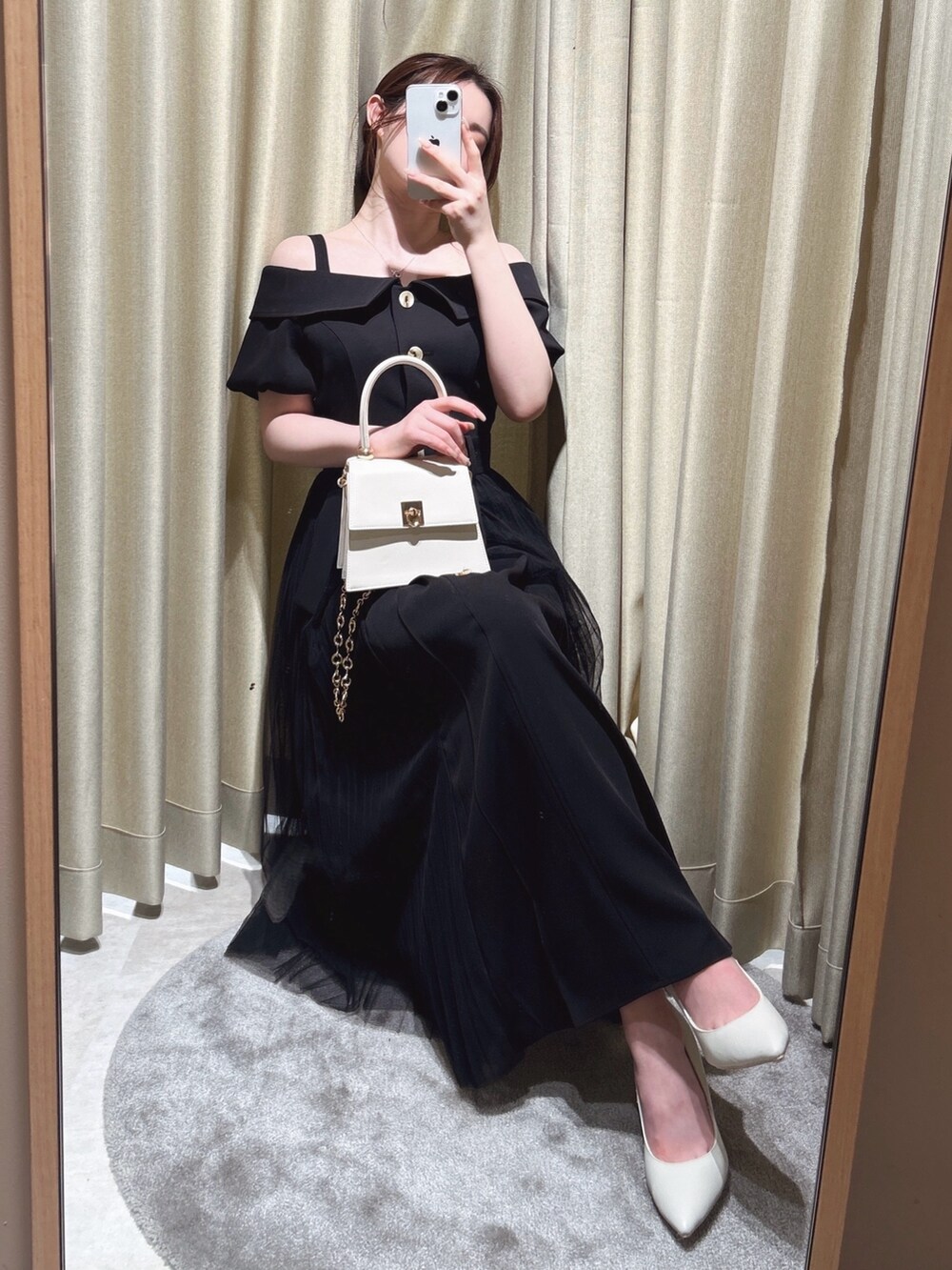 ブラック系のワンピース、ホワイト系のハンドバッグを着用したレディースの春コーディネートの2枚目の写真