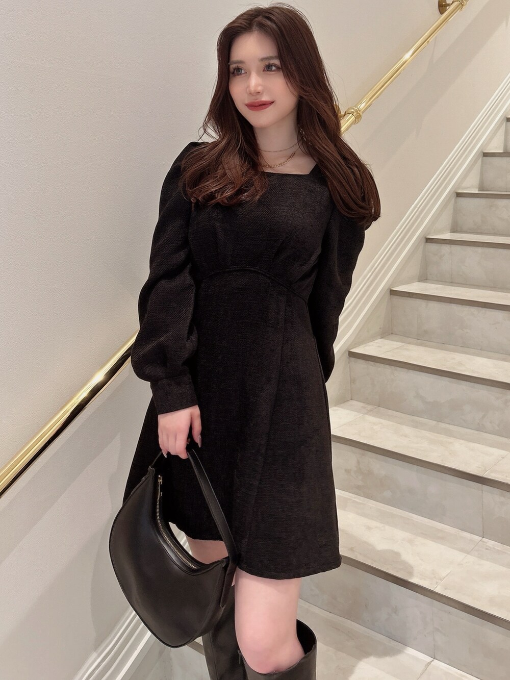 ブラック系のワンピース、ブラック系のハンドバッグを着用したレディースの秋コーディネートの2枚目の写真